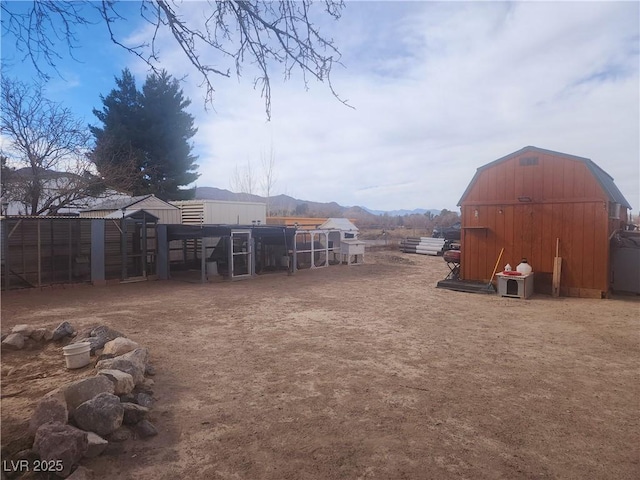 view of yard featuring a mountain view and an outdoor structure