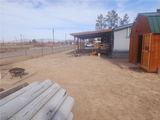 view of yard with a rural view, a fire pit, and an outdoor structure