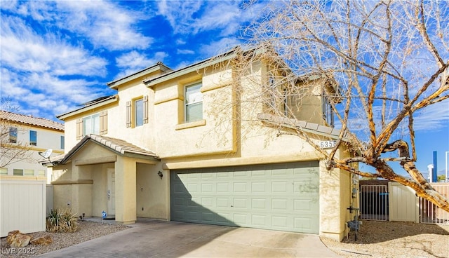 view of front of property featuring a tile roof, stucco siding, an attached garage, fence, and driveway