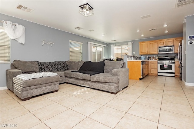 living area featuring visible vents and light tile patterned flooring