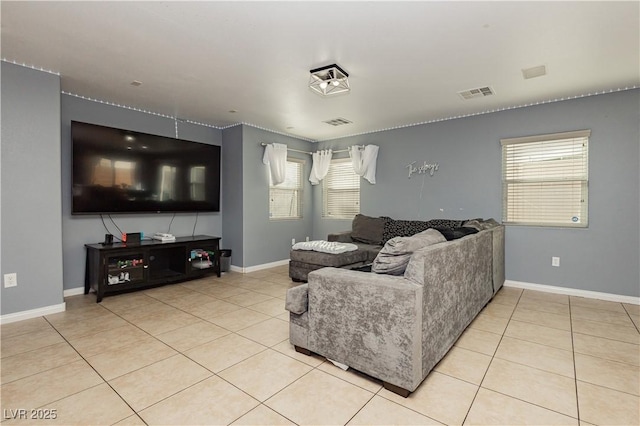 living area with a wealth of natural light, visible vents, baseboards, and light tile patterned floors