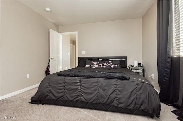 bedroom featuring light colored carpet and baseboards