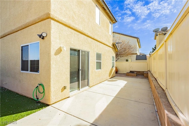 back of house featuring stucco siding, a fenced backyard, and a patio