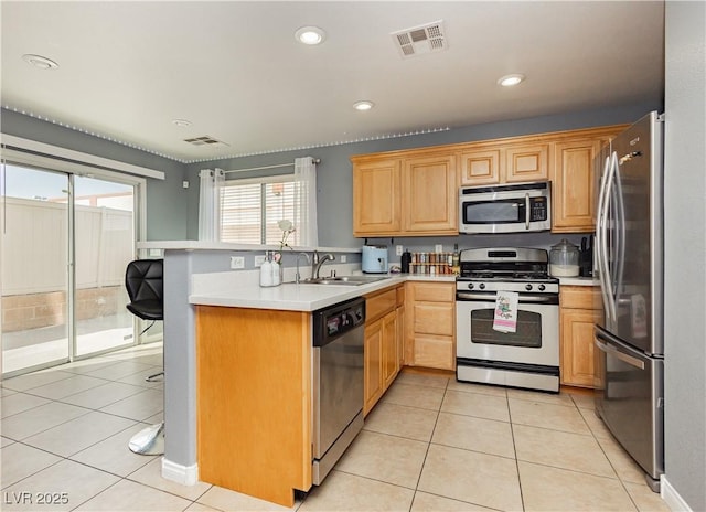 kitchen featuring light tile patterned floors, stainless steel appliances, visible vents, light countertops, and a peninsula