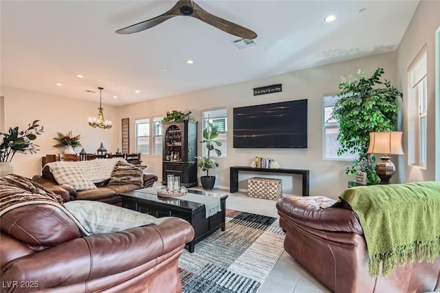 living room featuring ceiling fan with notable chandelier and light tile patterned floors