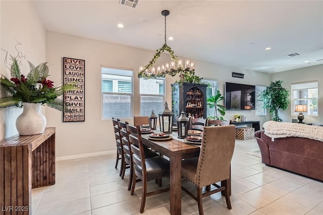 tiled dining space with an inviting chandelier