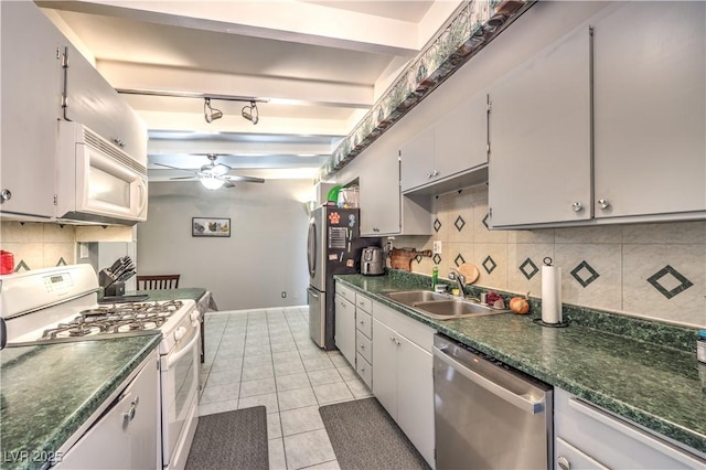 kitchen with light tile patterned flooring, sink, tasteful backsplash, appliances with stainless steel finishes, and ceiling fan