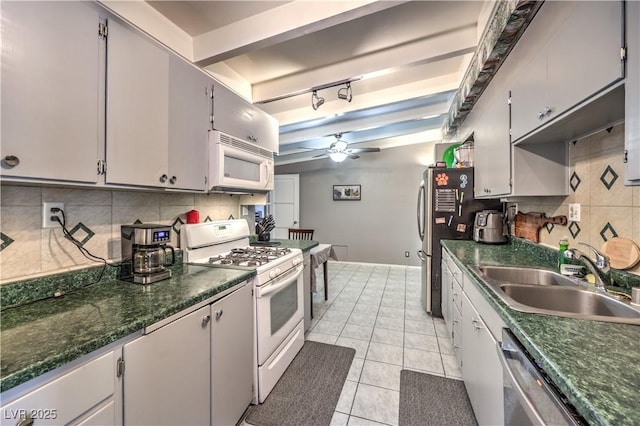 kitchen featuring sink, ceiling fan, appliances with stainless steel finishes, backsplash, and light tile patterned flooring