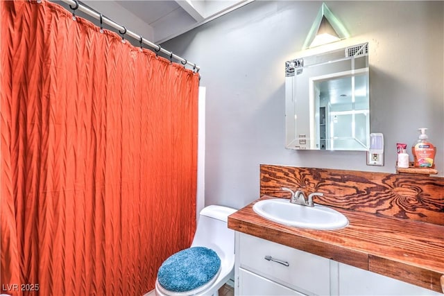 bathroom featuring vanity, walk in shower, and toilet