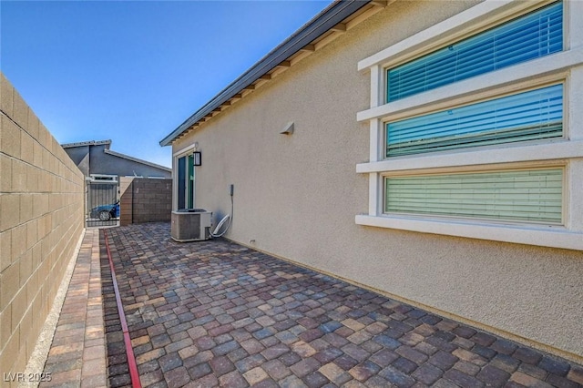 view of property exterior with central AC and a patio