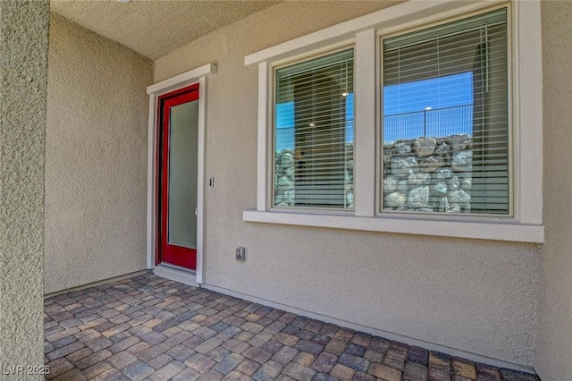 view of exterior entry with a patio area