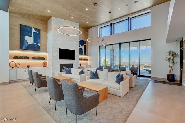 tiled living room featuring a towering ceiling and a fireplace