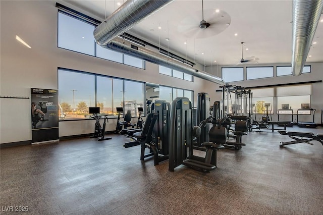 workout area featuring ceiling fan and a high ceiling