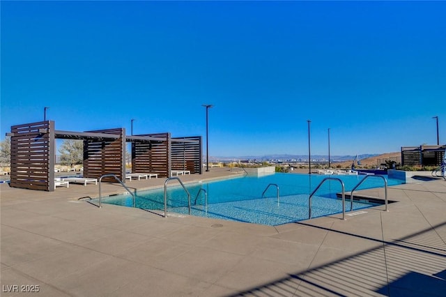 view of pool with a mountain view and a patio area