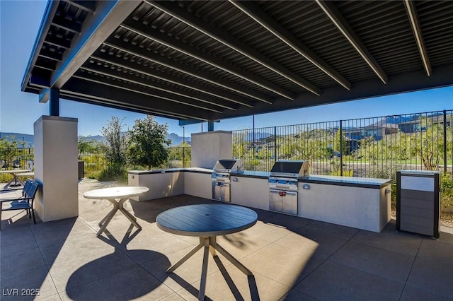 view of patio / terrace featuring an outdoor kitchen, a grill, and a mountain view