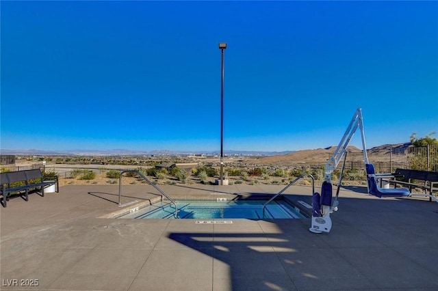 view of pool with a mountain view and a patio area