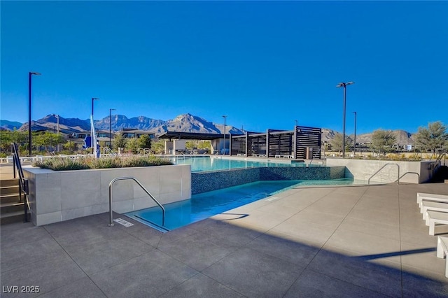 view of pool featuring a mountain view and a patio area