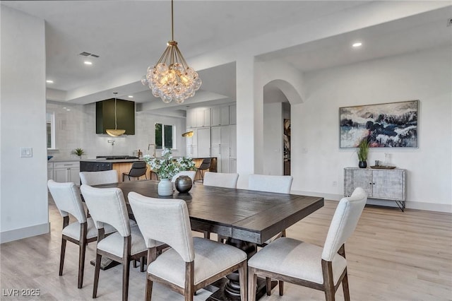 dining space featuring an inviting chandelier and light hardwood / wood-style floors