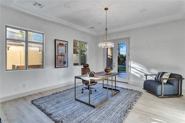 office area with light wood-style floors, a raised ceiling, visible vents, and baseboards