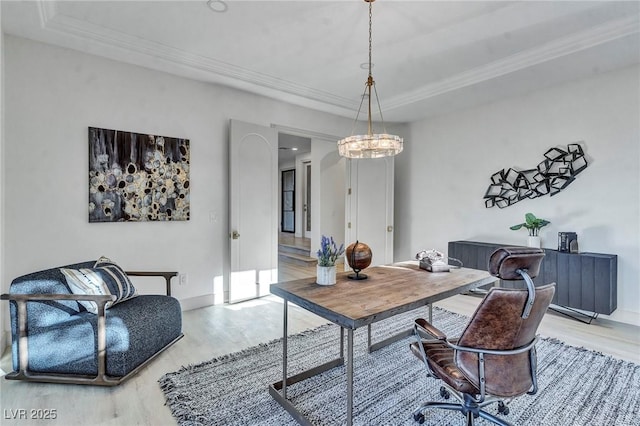 office space featuring light wood-style floors, a tray ceiling, and crown molding