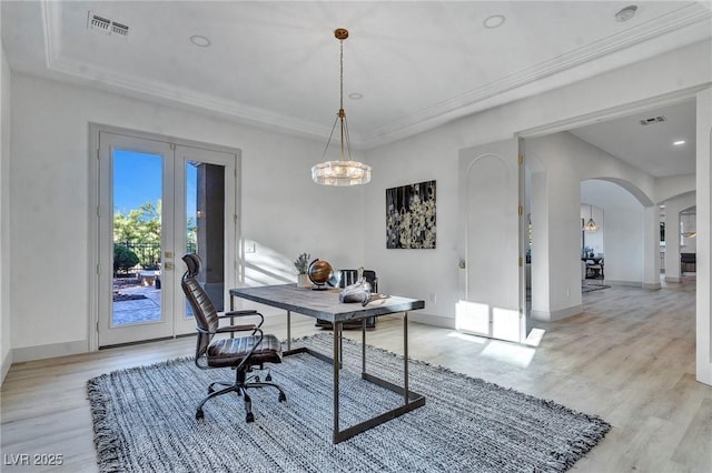 office featuring light hardwood / wood-style flooring, ornamental molding, and french doors