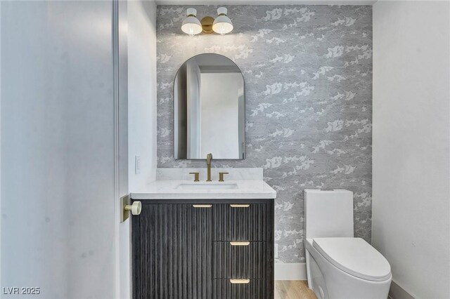 bathroom featuring vanity, wood-type flooring, and toilet