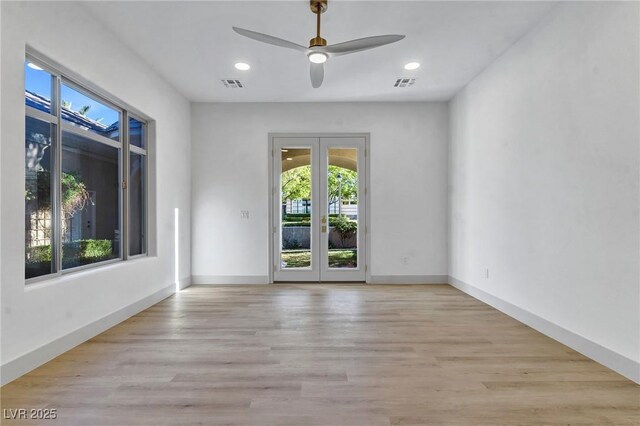 spare room with light hardwood / wood-style floors, french doors, and ceiling fan