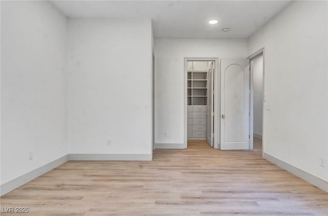 unfurnished room featuring recessed lighting, light wood-style flooring, and baseboards