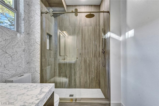 bathroom featuring a stall shower, vanity, and toilet