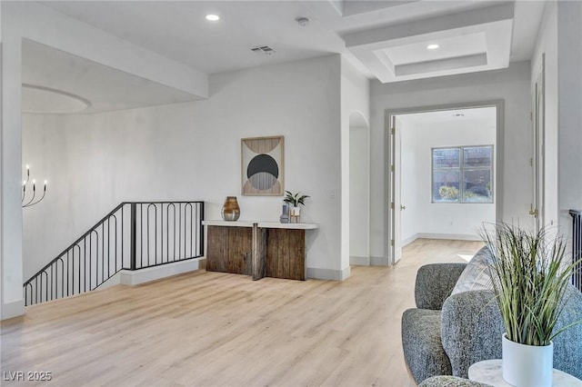 living area featuring visible vents, baseboards, arched walkways, light wood-style floors, and recessed lighting