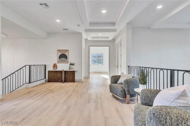 living area featuring a raised ceiling and light wood-type flooring