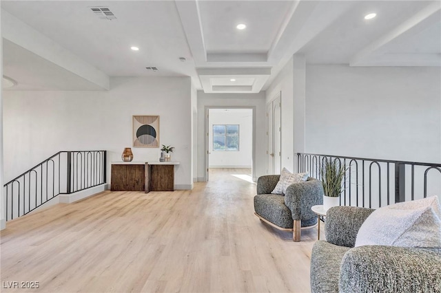 living area with recessed lighting, a raised ceiling, visible vents, light wood-style floors, and baseboards