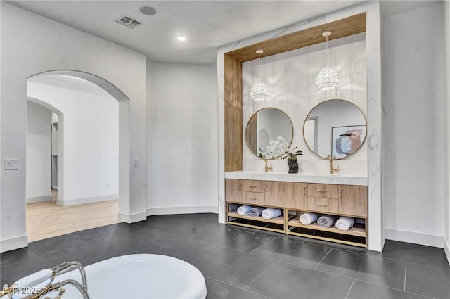 bathroom featuring tile patterned floors, vanity, and a bath