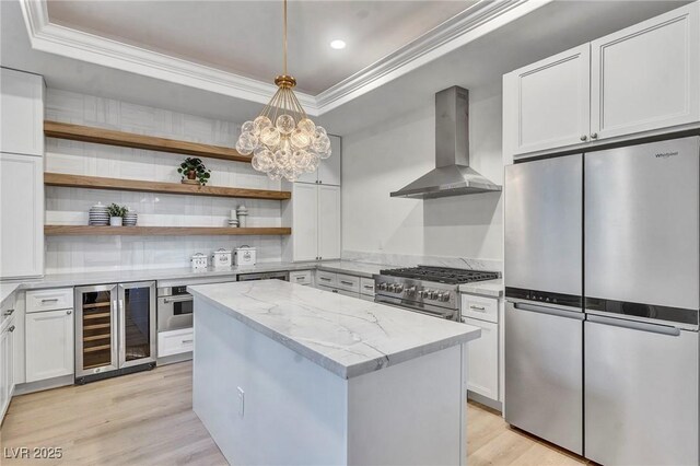 kitchen with white cabinetry, appliances with stainless steel finishes, a raised ceiling, and extractor fan