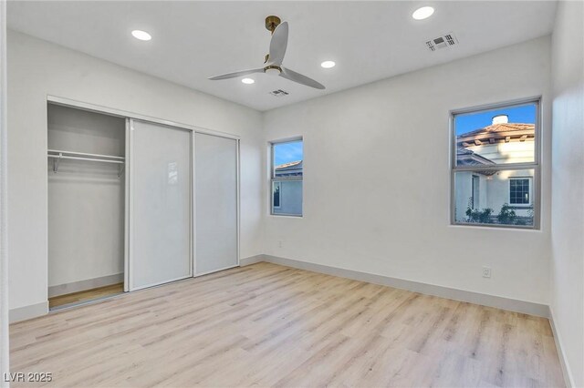 unfurnished bedroom with a closet, ceiling fan, and light wood-type flooring