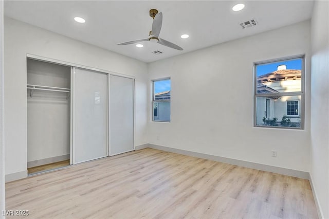 unfurnished bedroom featuring light wood-style flooring, visible vents, a closet, and recessed lighting