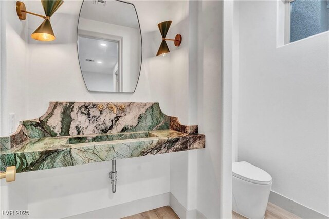 bathroom with sink, hardwood / wood-style flooring, and toilet