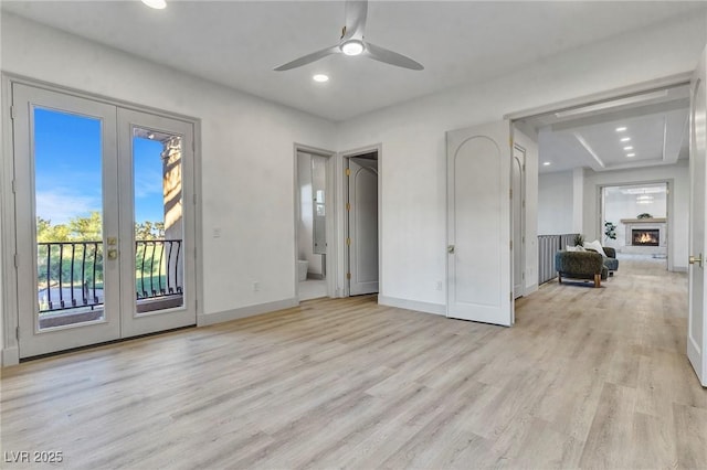 unfurnished bedroom featuring access to outside, baseboards, light wood-style flooring, and french doors