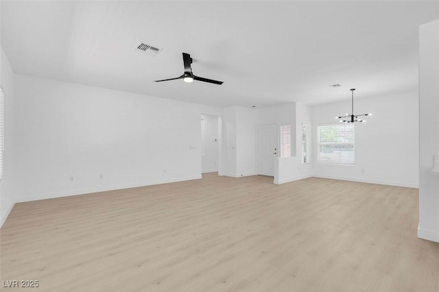 unfurnished living room with ceiling fan with notable chandelier and light hardwood / wood-style flooring