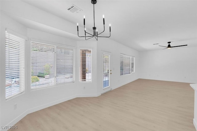 interior space featuring ceiling fan with notable chandelier and light hardwood / wood-style flooring