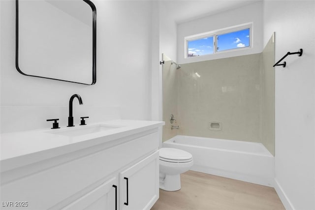 full bathroom with hardwood / wood-style flooring, tiled shower / bath, vanity, and toilet