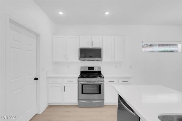 kitchen featuring white cabinetry, appliances with stainless steel finishes, and light hardwood / wood-style flooring