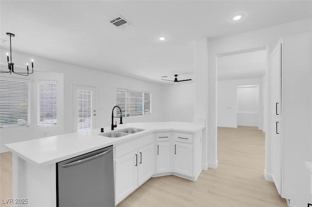 kitchen featuring sink, white cabinets, stainless steel dishwasher, light hardwood / wood-style floors, and kitchen peninsula