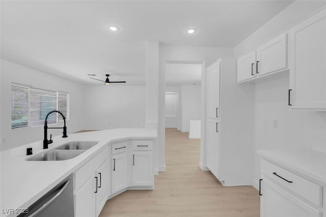 kitchen featuring white cabinetry, sink, light hardwood / wood-style floors, and dishwasher