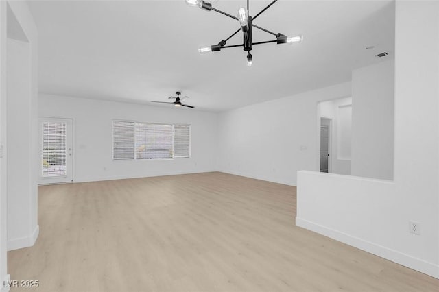 unfurnished living room with ceiling fan with notable chandelier and light hardwood / wood-style floors