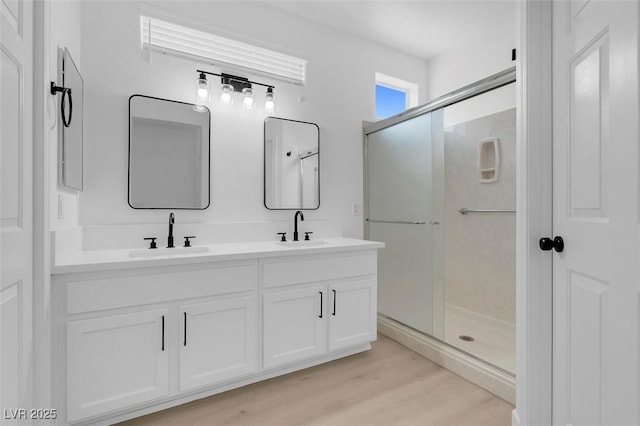 bathroom featuring hardwood / wood-style flooring, vanity, and an enclosed shower