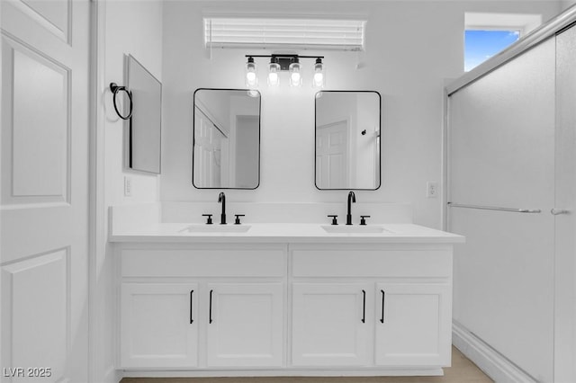 bathroom with a shower with door and vanity