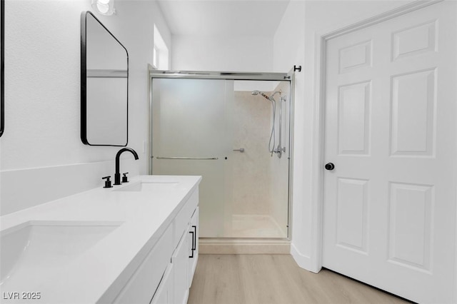 bathroom featuring hardwood / wood-style flooring, vanity, and an enclosed shower