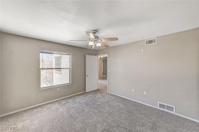 unfurnished room with ceiling fan, light colored carpet, and a textured ceiling