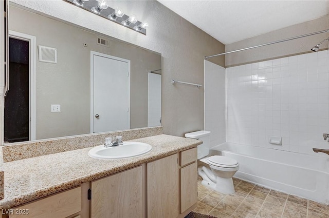 full bathroom with tiled shower / bath, vanity, and toilet